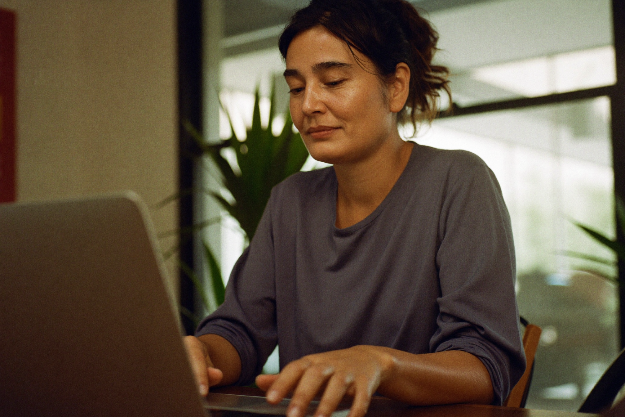 A clinician reviewing a completed patient intake form on a laptop in a bright consult room